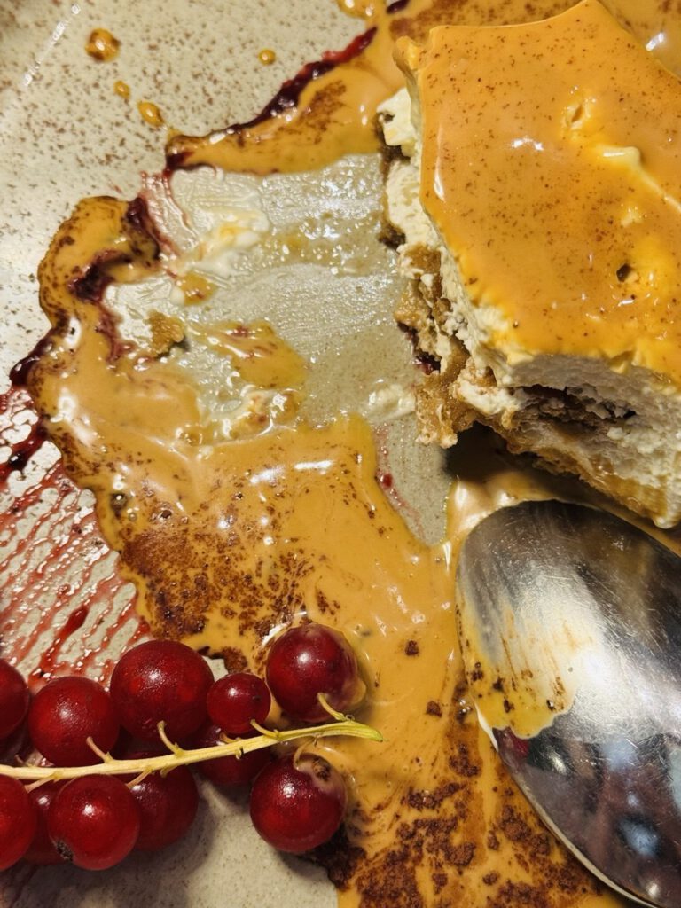 Dessert plate with caramel sauce, cake, and fresh redcurrants